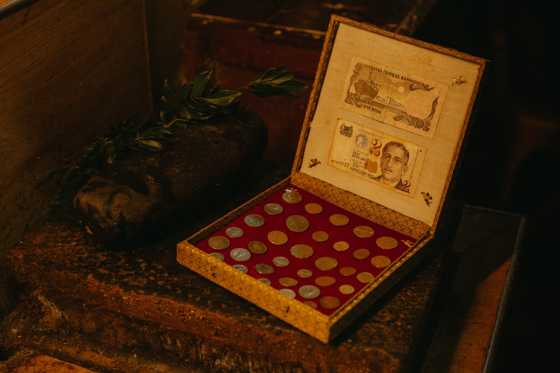 A small ornate box of collected coins and old banknotes